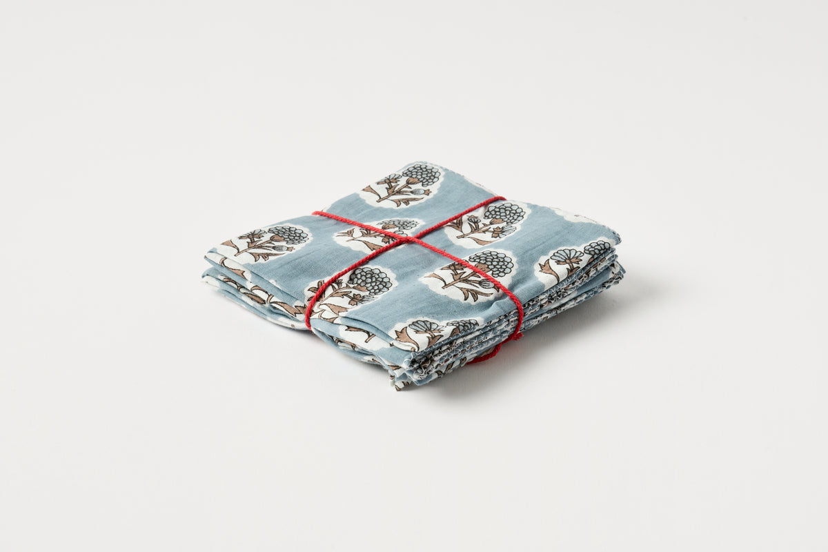 Folded fabric with a pattern tied with red string on a light gray background