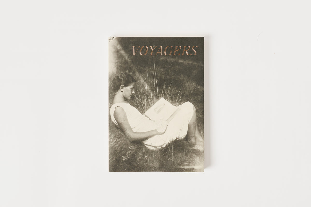 Book titled 'Voyagers' with a cover featuring a woman in a white dress on a light gray background