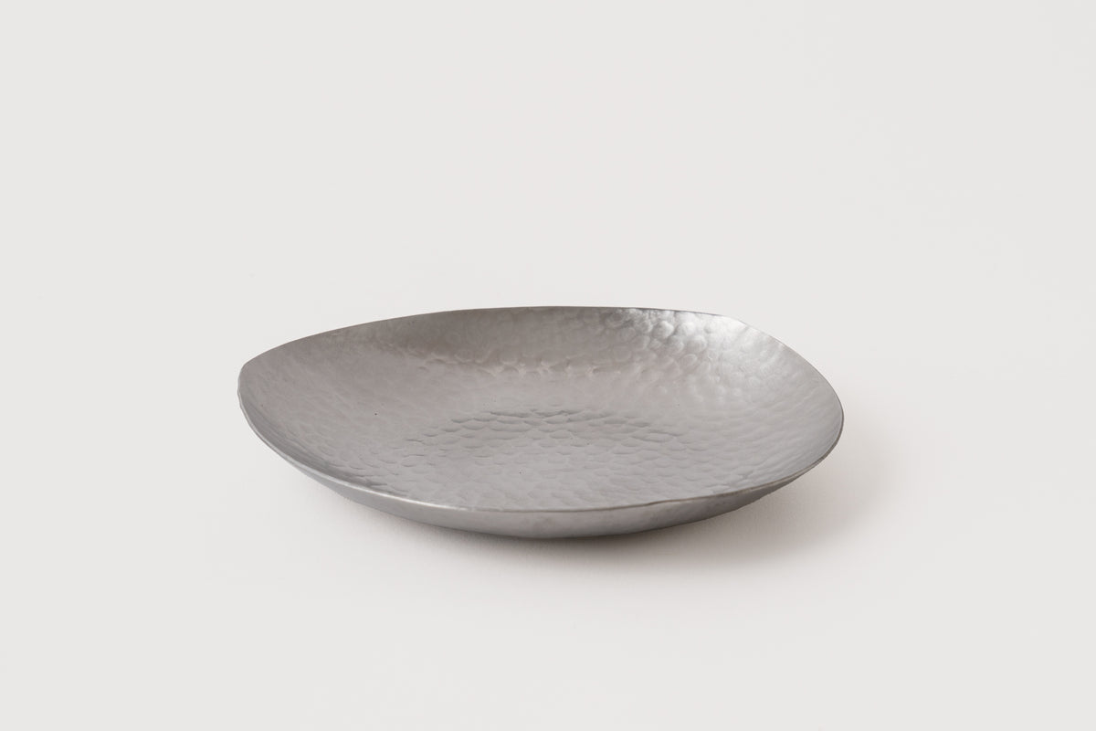 A silver stainless steel dish with a hammerd finish on a white background.