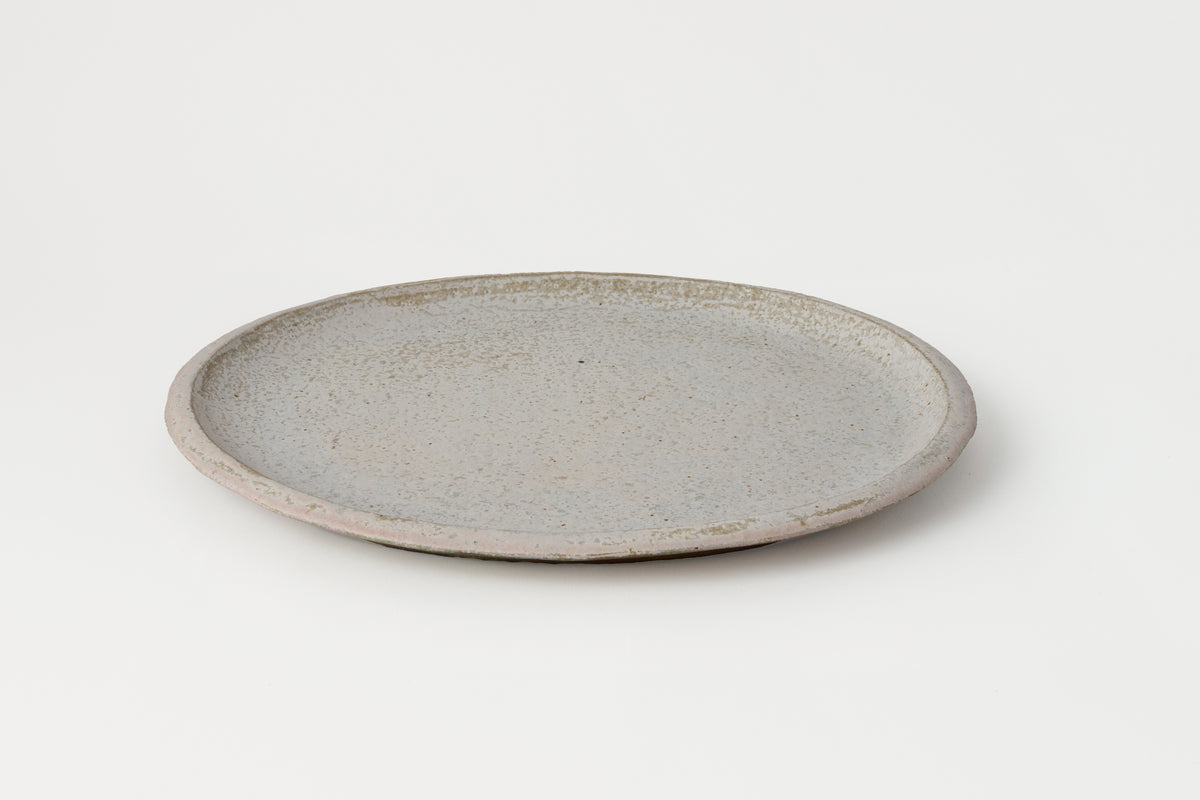 Round ceramic plate with a textured surface on a white background