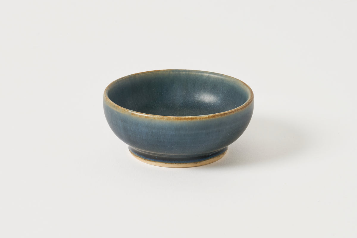 small blue bowl in navy photographed on a white background