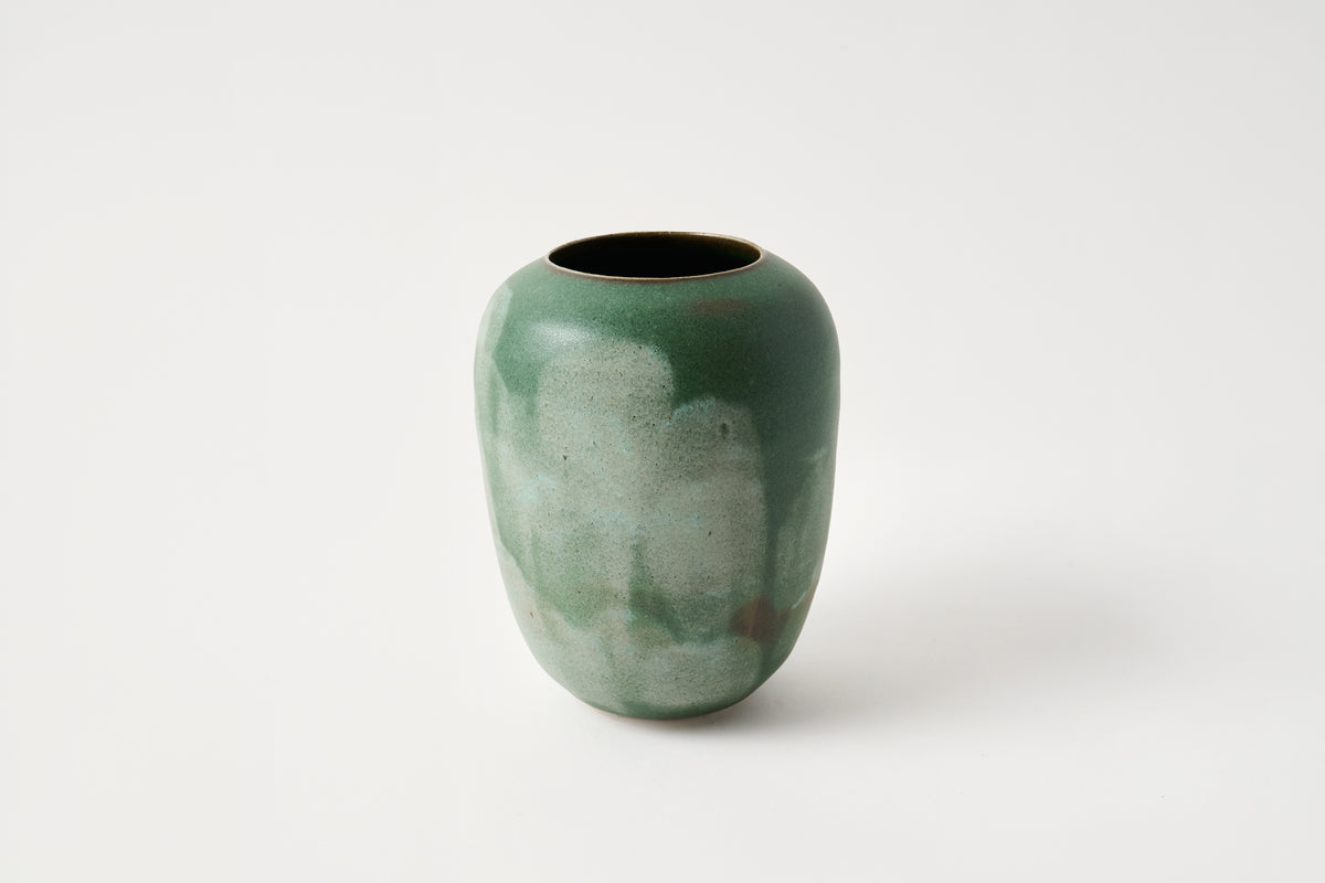 Green ceramic vase on a white background
