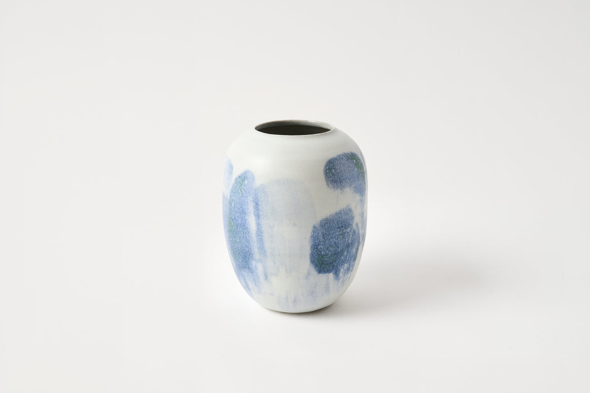 Ceramic vase with blue abstract patterns on a white background