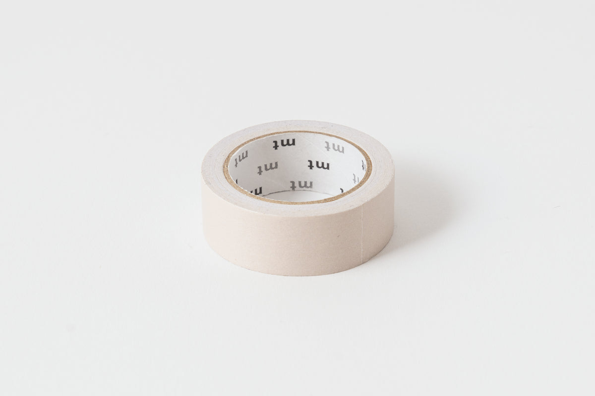 A roll of pastel cocoa colored washi masking tape on a white background