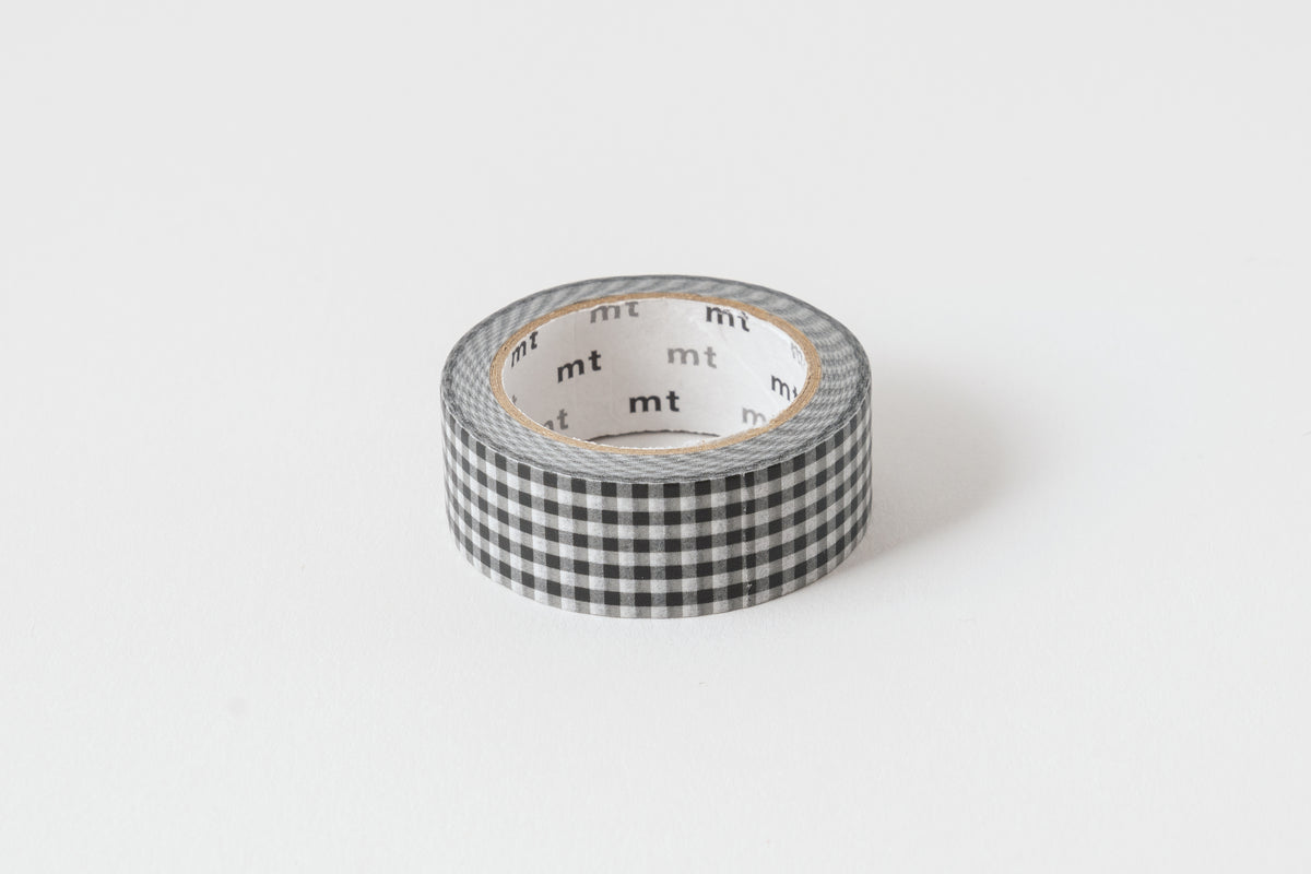 A roll of checkered black and white washi tape with the brand 'mt' visible on the tape.