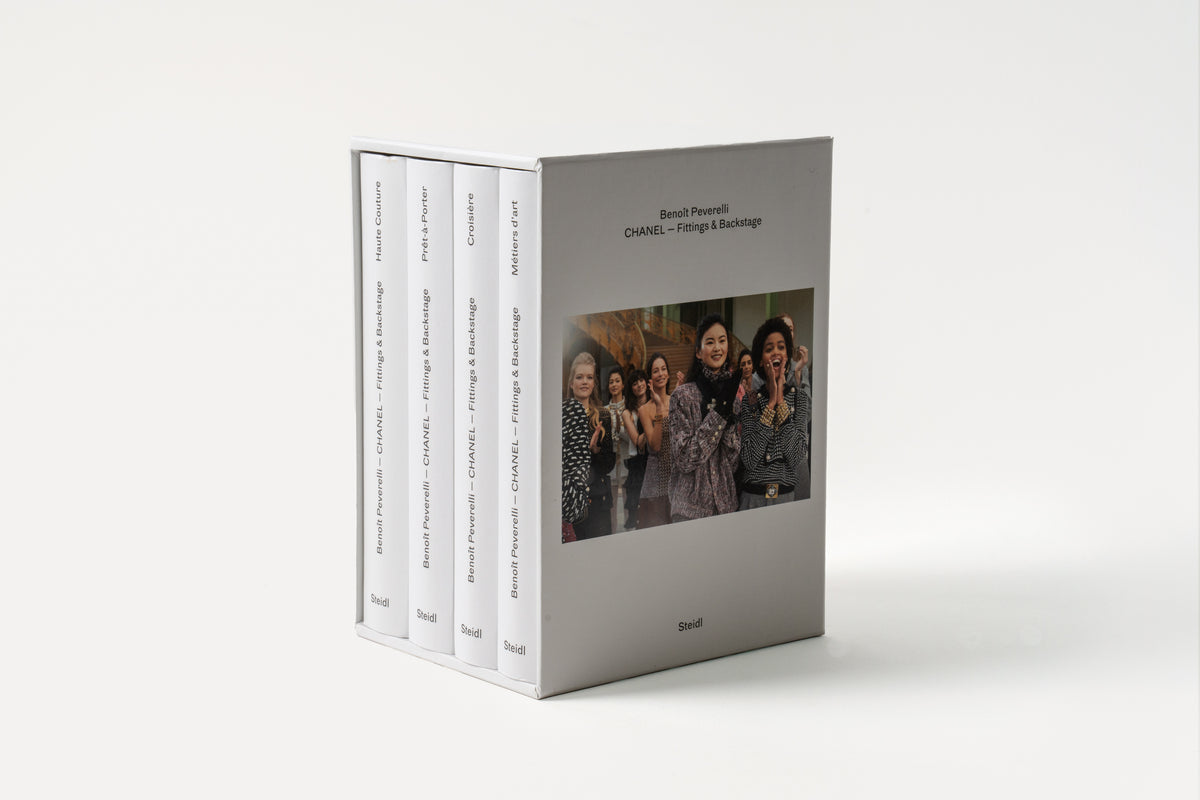 A set of four books with the title 'CHANEL - Fittings and Backstage' by Benoët Peverelli, featuring photographs of the inner workings of a fashion show with a focus on Chanel's collections.