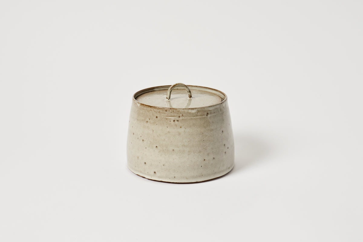 Ceramic candle holder with a speckled texture on a white background