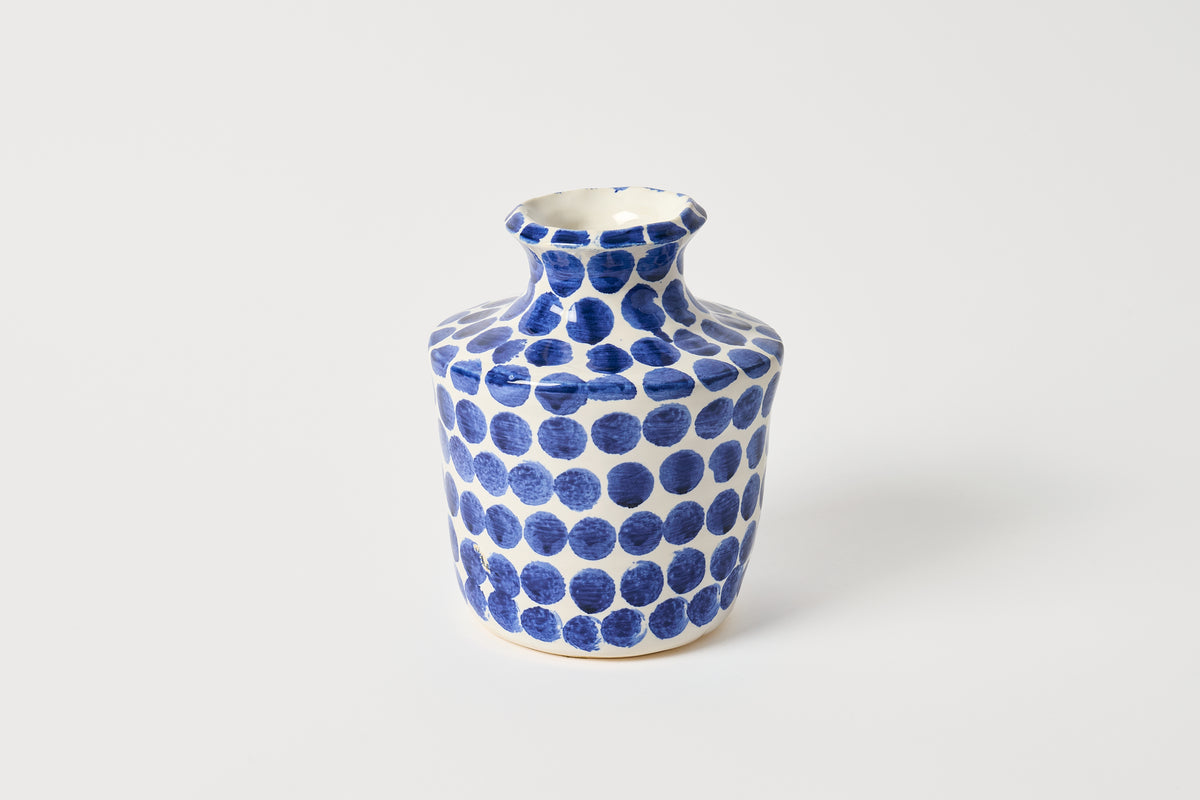 Ceramic vase with blue dot pattern on a white background