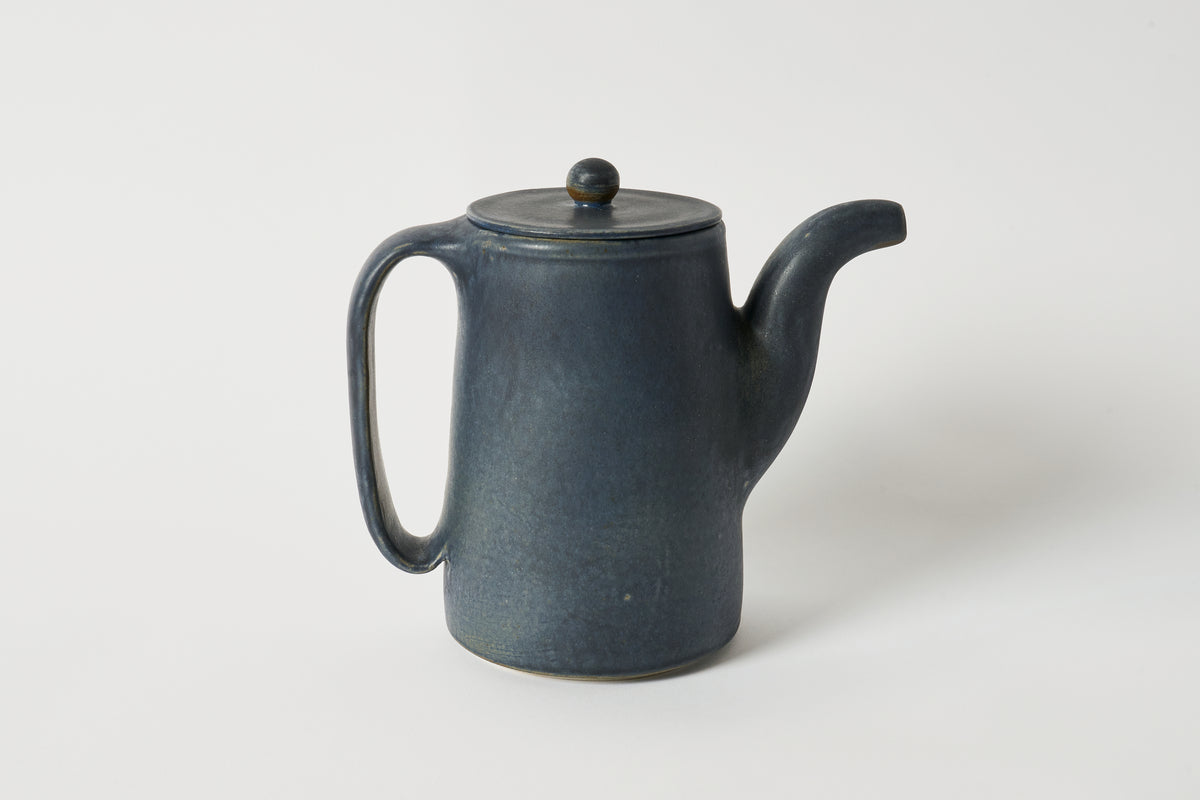 Dark blue ceramic teapot on a white background