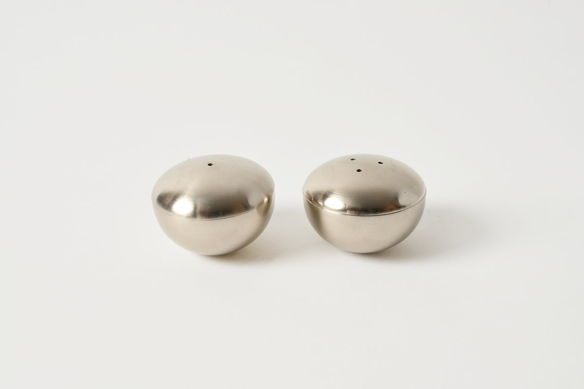 Two metallic salt and pepper shakers on a white background
