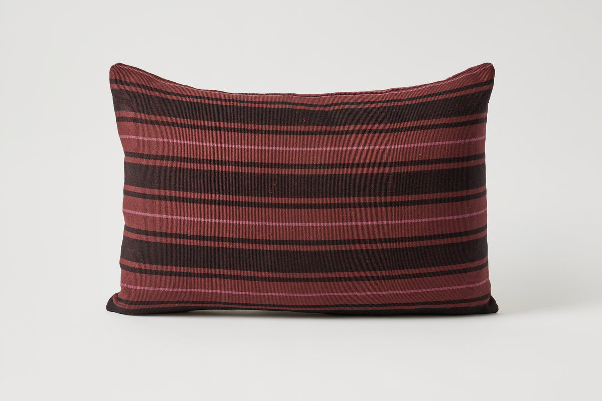 A rectangular throw pillow with horizontal stripes in deep burgundy and black, set against a plain light gray background.