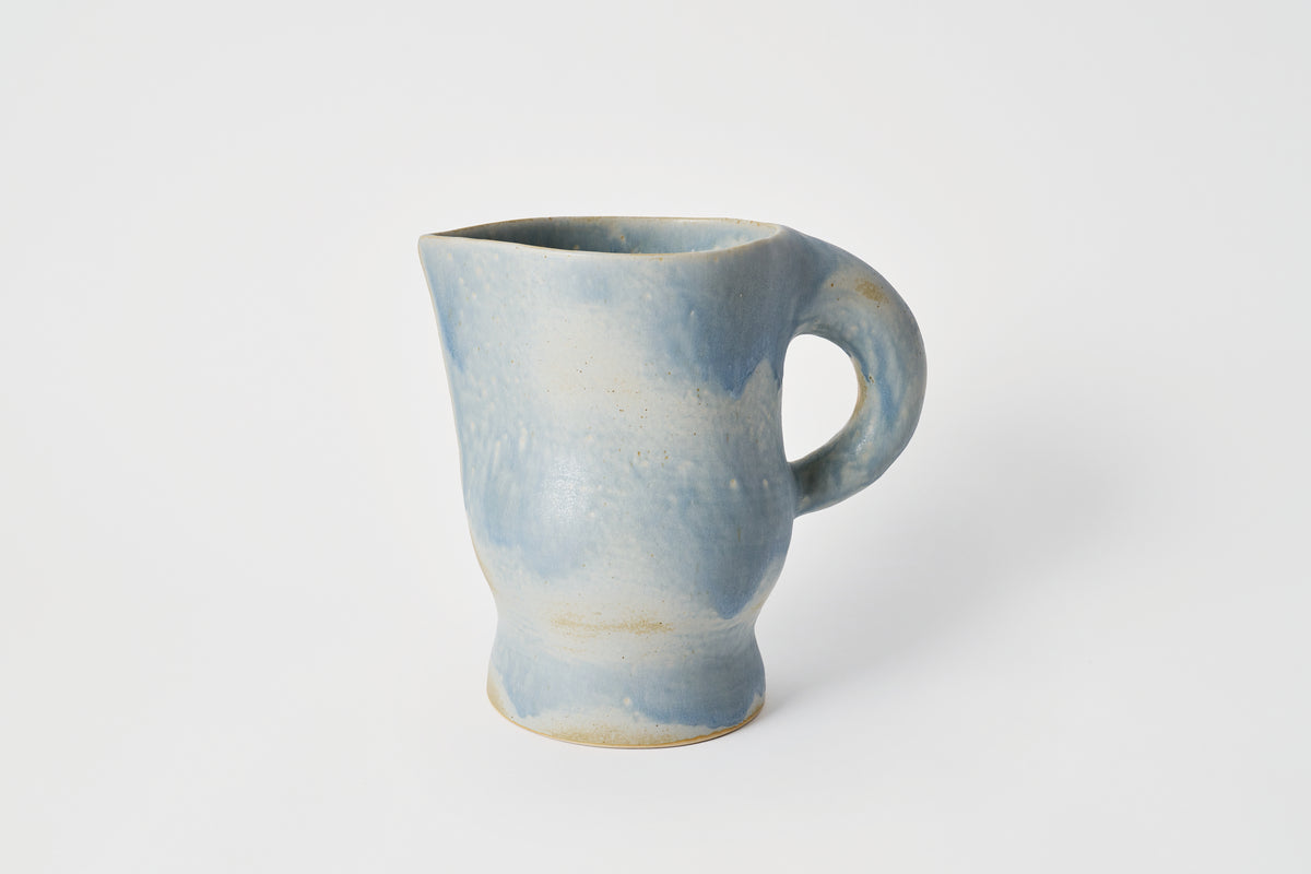 Blue ceramic pitcher on a white background