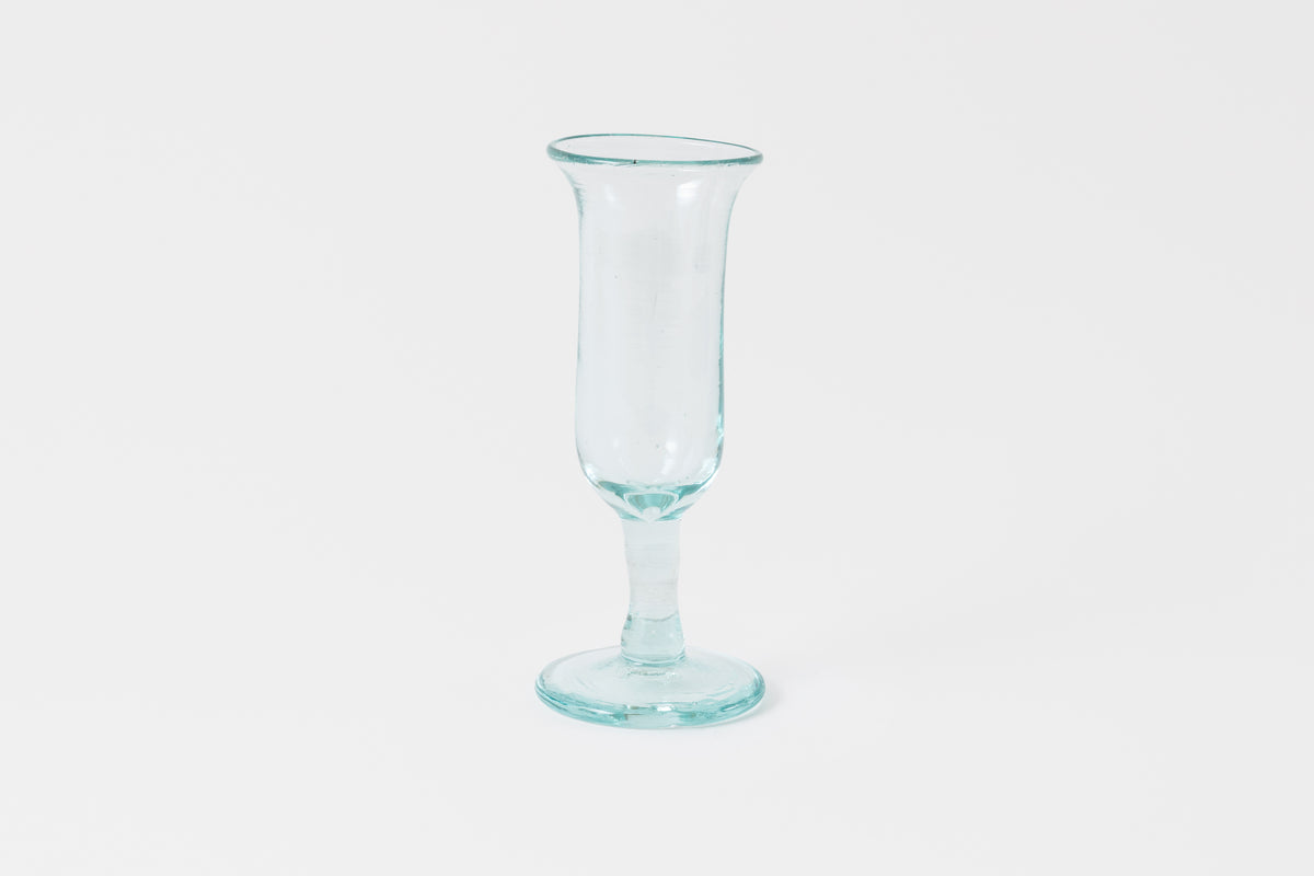 A clear glass tulip-shaped champagne glass with a solid pattern and no visible contents.