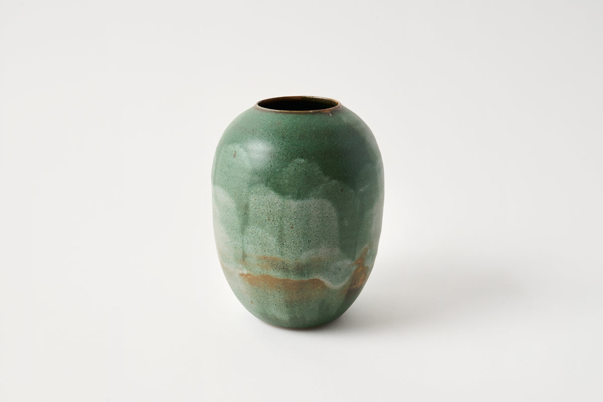 Green ceramic vase on a white background