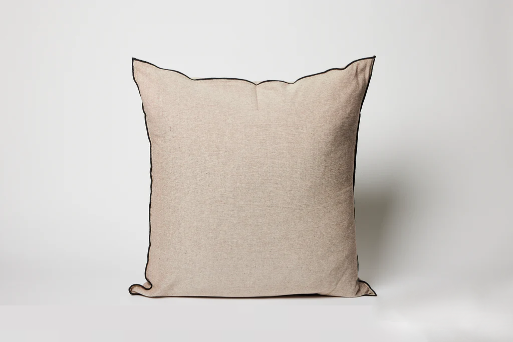 Beige pillow with a dark brown border on a white background