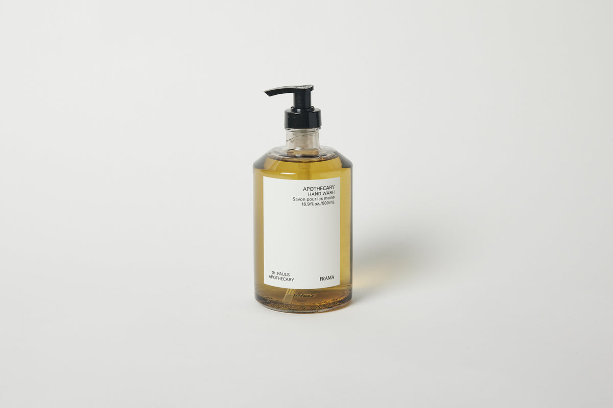 A pump bottle of Frama Apothecary hand wash, 500ml, with a yellow label and clear liquid visible through the bottle.